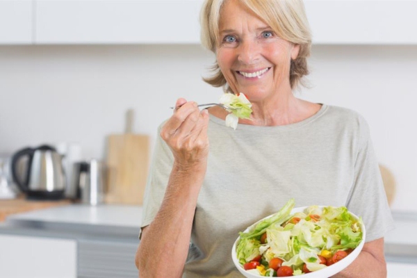 Женщина кушает салат 